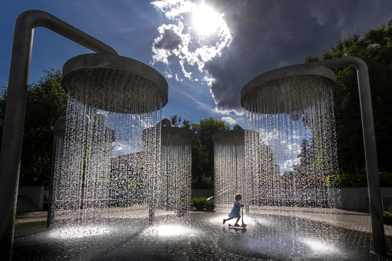 A girl cools off in a public fountain in Vilnius, Lithuania, Friday. (AP-Yonhap)