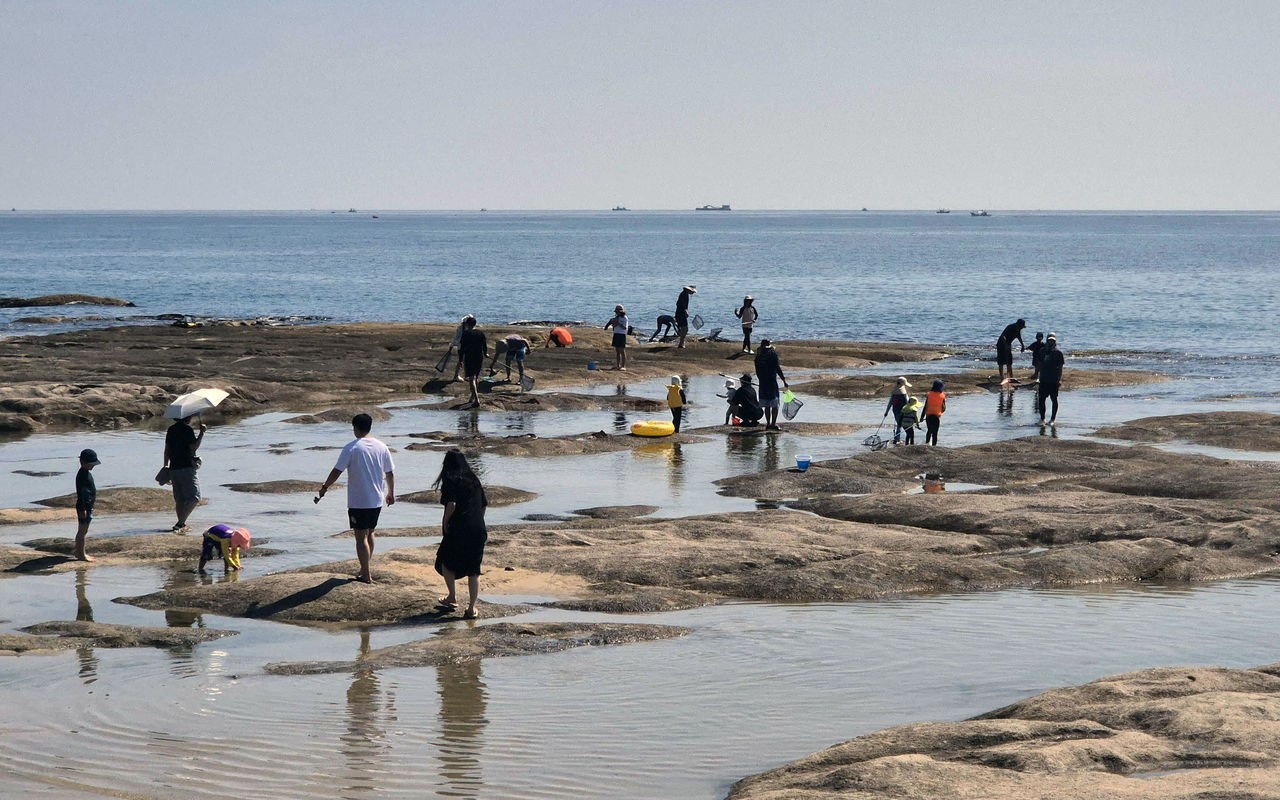 Beachgoers cool off at Ayajin Beach in Goseong, Gangwon Province, on Sunday. Beaches along Gangwon’s east coast, including those in Gangneung, Sokcho, Donghae, Samcheok, Yangyang and Goseong, will open in phases through mid-July. (Yonhap)
