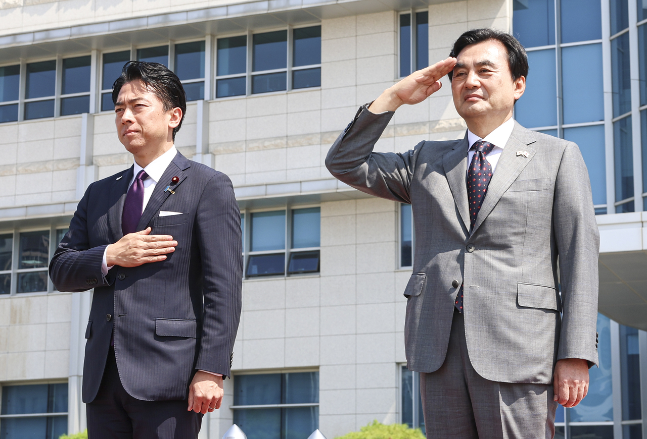 South Korean Defense Minister Ahn Gyu-back (right) salutes next to Japanese Defense Minister Shinjiro Koizumi during an honor guard ceremony at the Defense Ministry headquarters in Yongsan, central Seoul, Sunday. (Joint Press Corps via Yonhap)