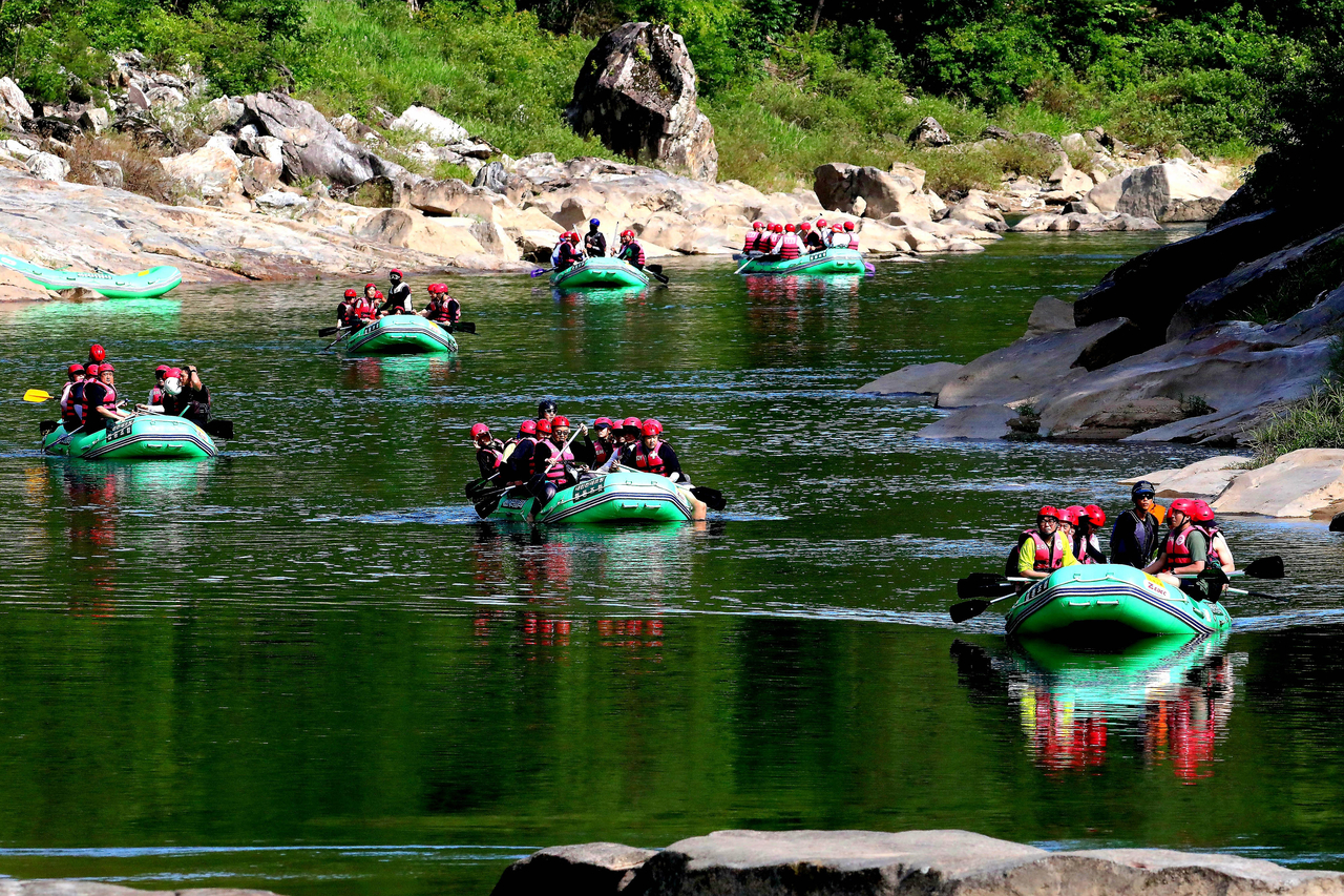 Tourists enjoy rafting on Naerincheon Stream in Inje, Gangwon Province, on Saturday, seeking relief from the summer heat. The stream is considered one of South Korea’s top rafting destinations for its long rapids and mix of fast and gentle currents. (Yonhap)