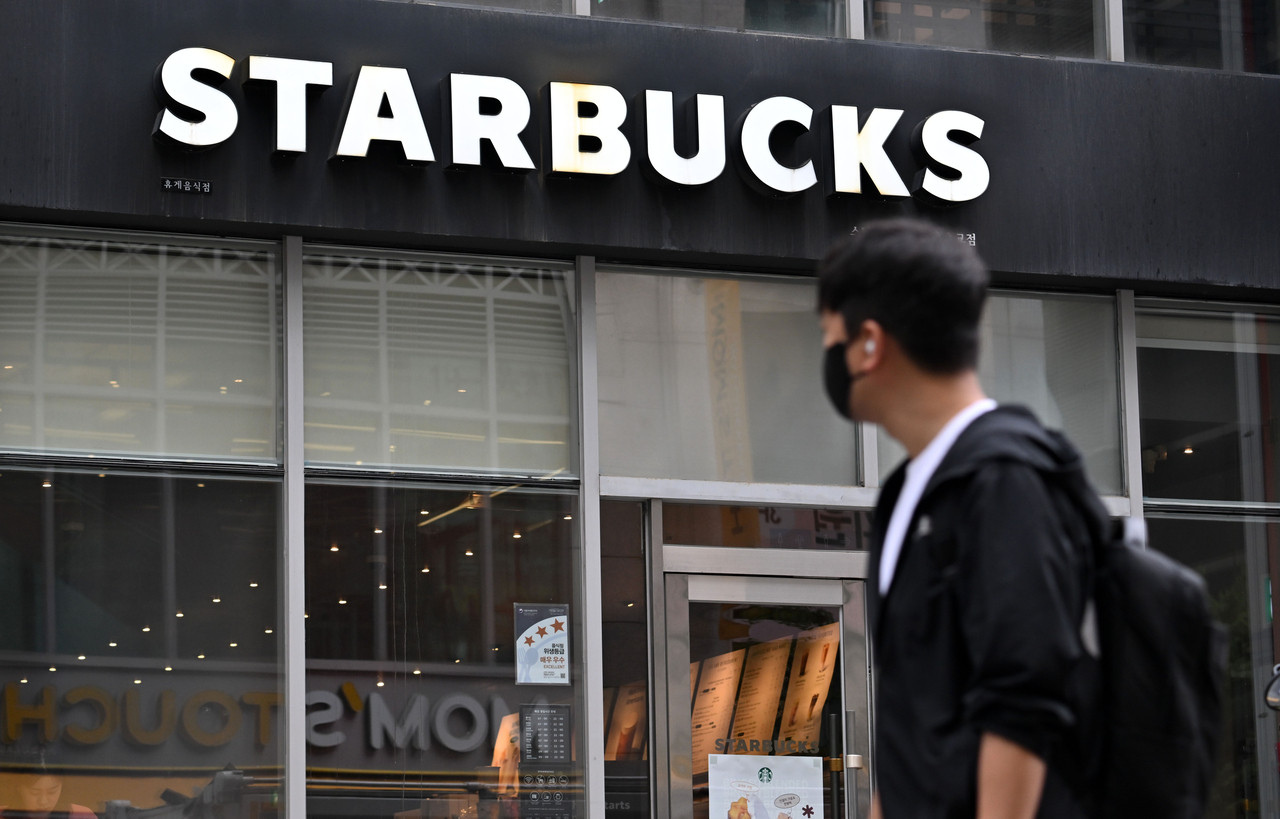A passenger walks by a Starbucks store in Seoul. (Im Se-jun/The Korea Herald)