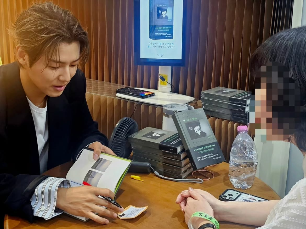 Kang Min-hyuk signs a book for a fan at the 2026 Seoul International Book Fair. (@dreambooks.ceo)