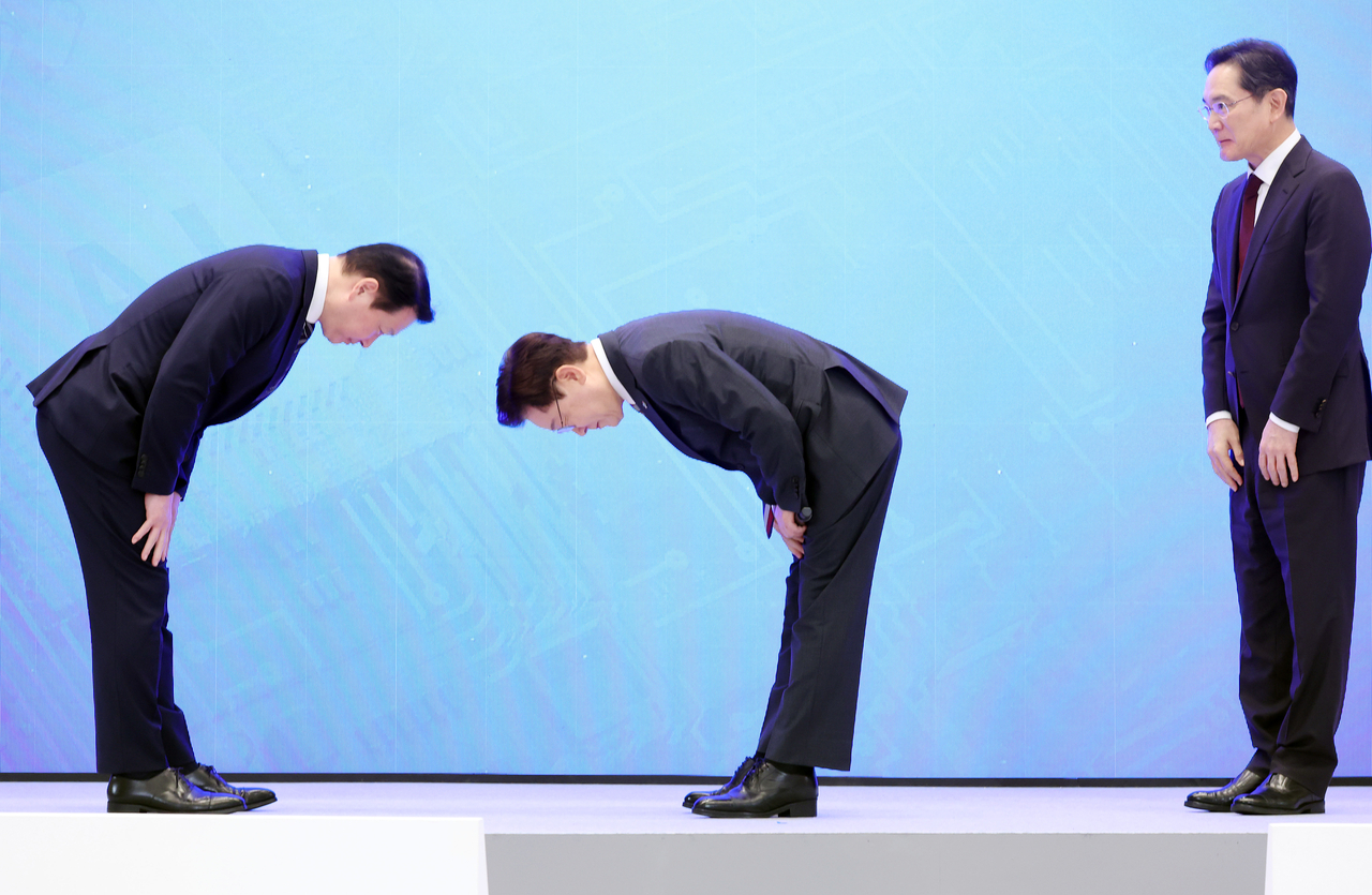 President Lee Jae Myung makes a deep bow to SK Group Chair Chey Tae-won after a presentation on corporate investment plans during the public briefing on South Korea's three flagship "mega projects" at Cheong Wa Dae in Seoul on Monday. Samsung Electronics Chair Lee Jae-yong is seen at right. (Pool photo via Yonhap)