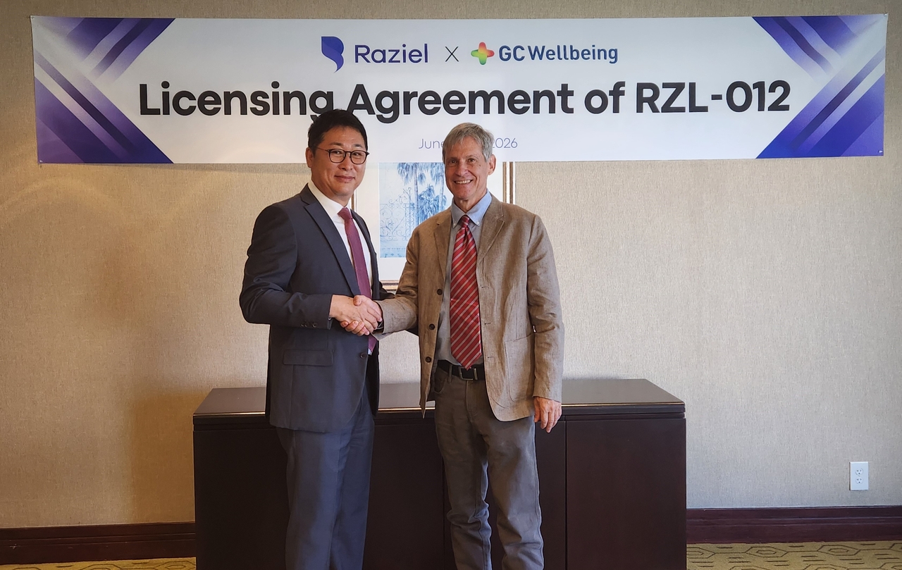 GC Wellbeing CEO Kim Sang-hyun (left) and Raziel Therapeutics CEO Alon Bloomenfeld pose for a photo after signing a license-in agreement at The Westin South Coast Plaza in Costa Mesa, California, on June 25. (GC Wellbeing)