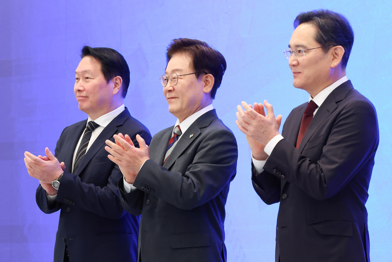 President Lee Jae Myung, Samsung Electronics Chairman Lee Jae-yong and SK Group Chairman Chey Tae-won applaud following the presentation of corporate investment plans at a public briefing on South Korea's three flagship "megaprojects" at Cheong Wa Dae on Monday. (Pool Photo via Yonhap)