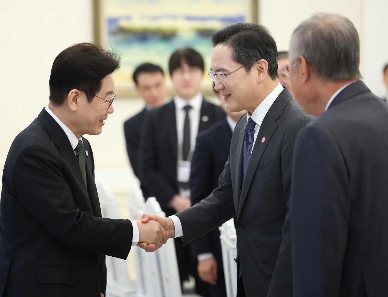 President Lee Jae Myung (L) shakes hands with Samsung Electronics Co. Chairman Lee Jae-yong during an event at Cheong Wa Dae in Seoul in this Feb. 4, file photo. (Yonhap)