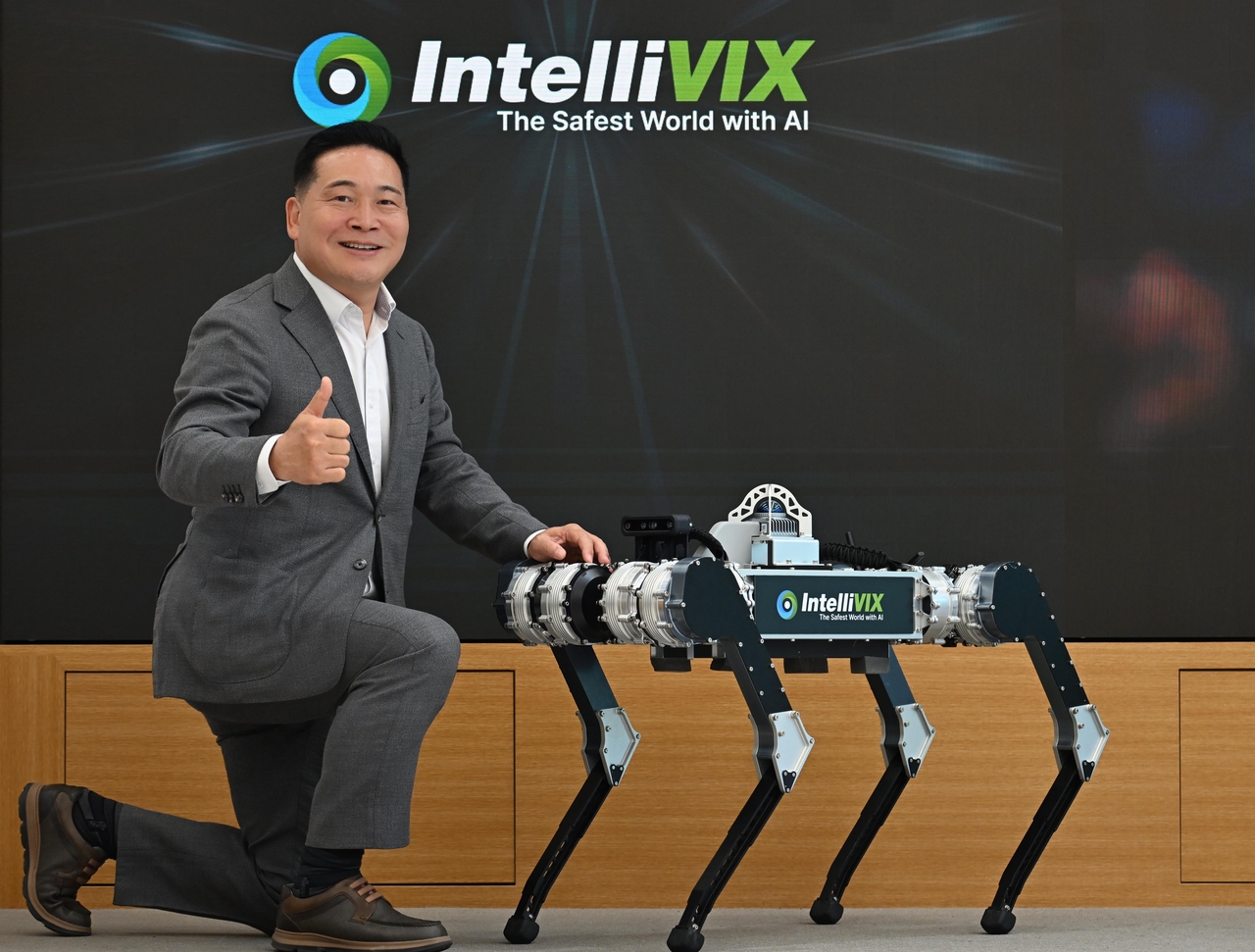 Intellivix CEO Choi Eun-soo poses with Argos, the company’s AI patrol robot, at the company’s headquarters in Seoul on Tuesday. (Lee Sang-sub/The Korea Herald)