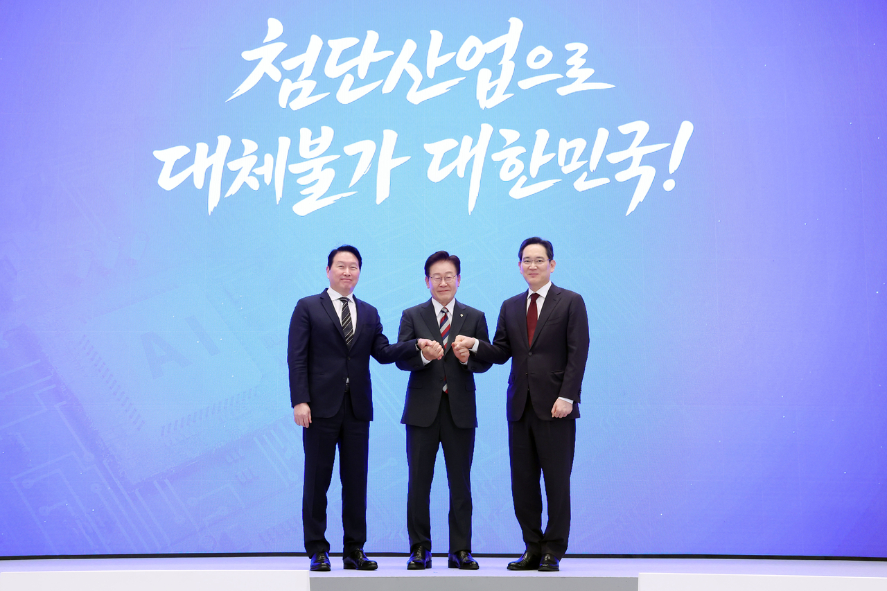 From left: SK Group Chairman Chey Tae-won, President Lee Jae Myung and Samsung Electronics Chairman Lee Jae-yong hold hands after announcing corporate investment plans at Cheong Wa Dae in Seoul on Monday. (Yonhap)