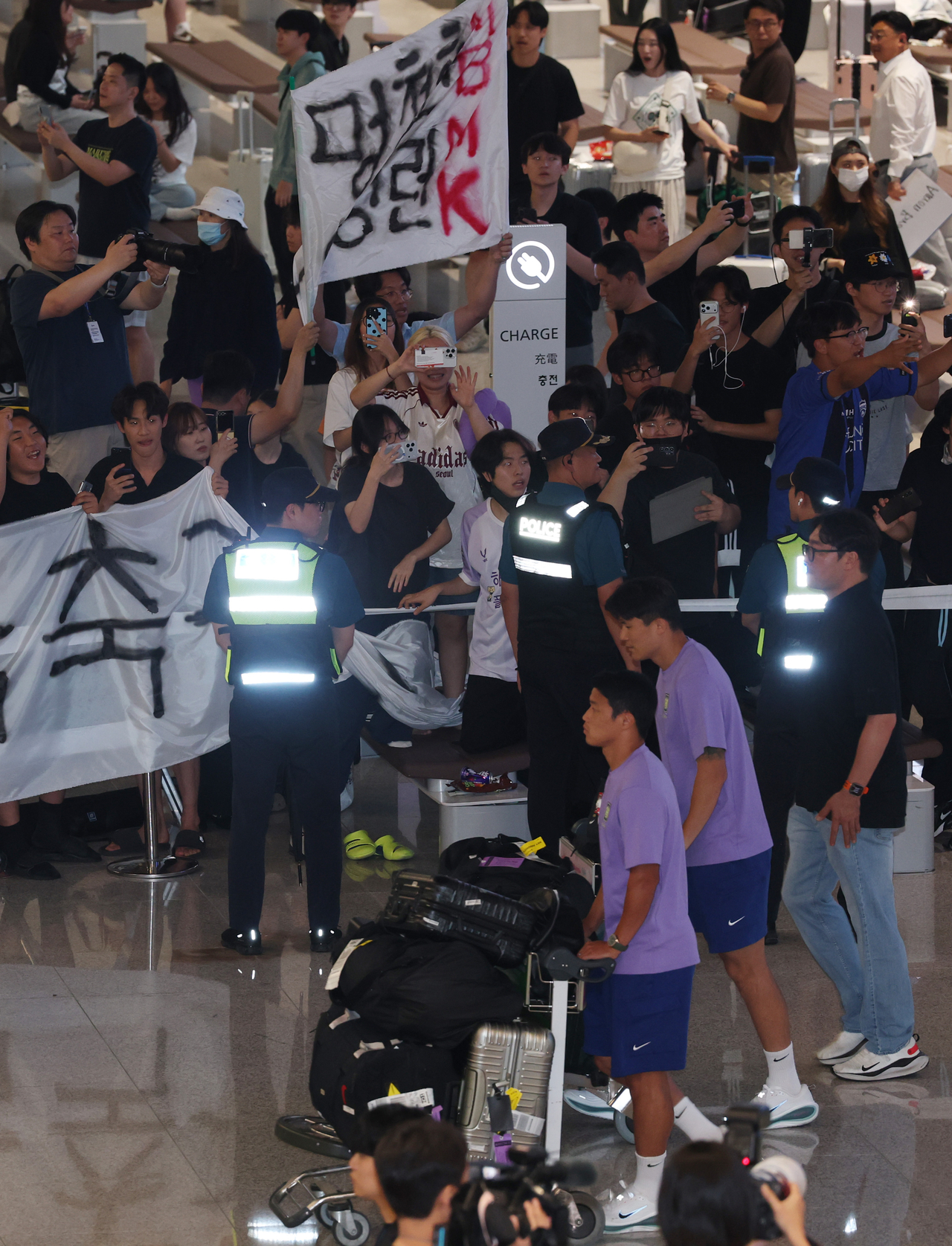 Soccer fans hold banners criticizing South Korea head coach Hong Myung-bo as the national team arrives at Incheon International Airport's Terminal 2 on June 30, following its group-stage elimination from the 2026 FIFA World Cup. (Im Se-joon/The Korea Herald)