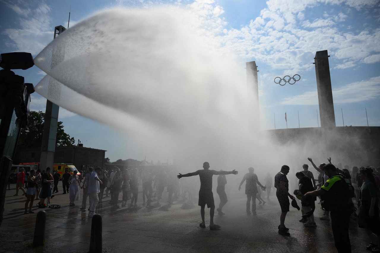 Police use water cannon to spray people with water as the arrive at the Olympic stadium for a concert in Berlin on Sunday. (AFP-Yonhap)