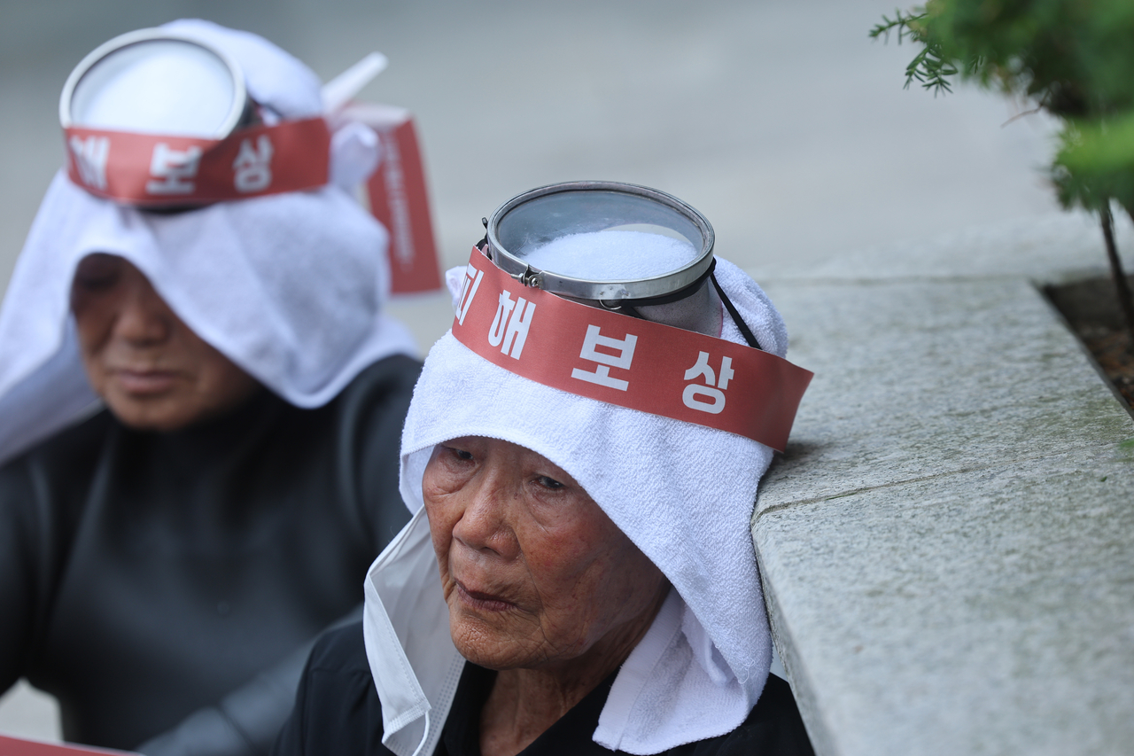 Protesting haenyeo, or traditional Korean female divers, listen to a speaker during a rally outside Ssangyong Engineering & Construction's headquarters in Seoul on Monday. (Yonhap)