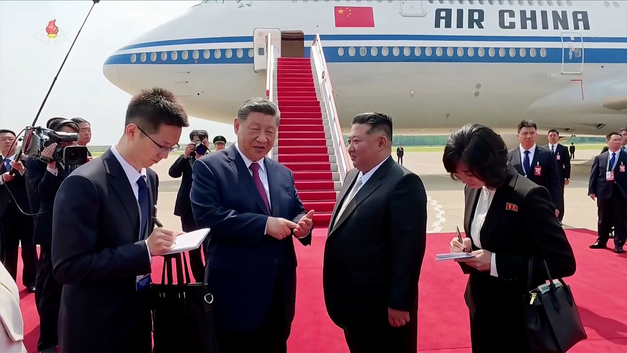 North Korean leader Kim Jong-un (center right) and Chinese President Xi Jinping talk at Pyongyang International Airport on June 9 before Xi boarded his plane after wrapping up a two-day state visit to North Korea. (Korean Central Television via Yonhap)