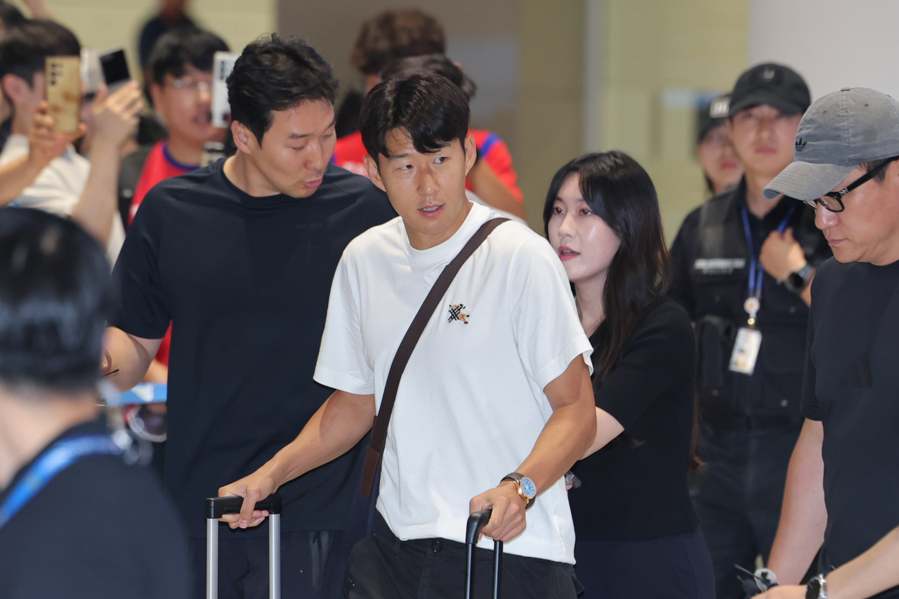 Son Heung-min (center), captain of the South Korean men's national football team, walks toward the exit at Incheon International Airport, west of Seoul, on July 1, after arriving back from the FIFA World Cup. (Yonhap)
