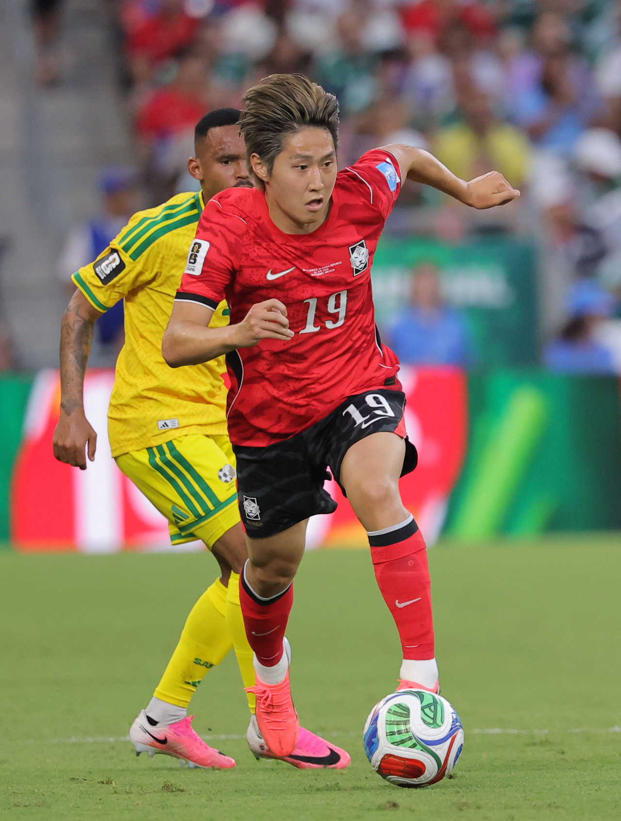South Korea’s Lee Kang-in (front) dribbles the ball against South Africa at the World Cup, in Monterrey, Mexico, June 24.   (Yonhap)