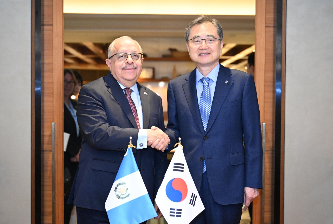 Foreign Minister Cho Hyun (right) poses for a photo with Guatemalan Foreign Minister Carlos Martinez during a meeting in Seoul, Wednesday. (Yonhap)