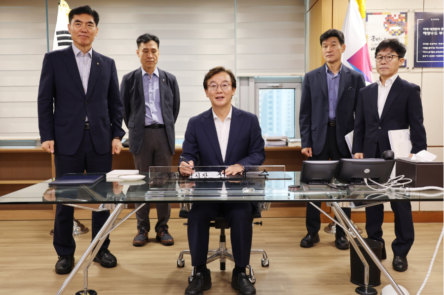 Busan Mayor Jeon Jae-soo signs off on the city's 100-day emergency livelihood plan at his office on Wednesday. [Busan City]