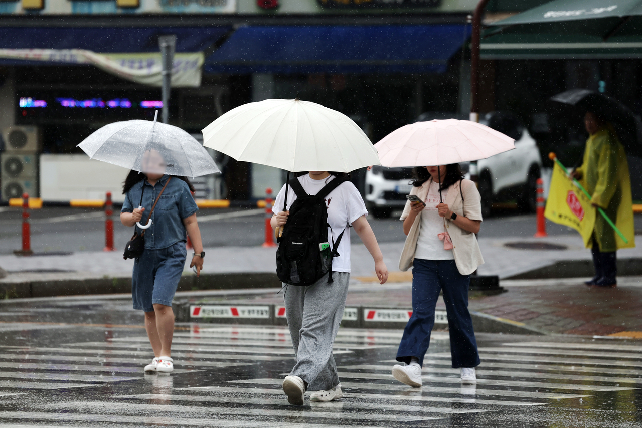 Pedestrians walk with umbrellas along a street in Ochi-dong, Buk-gu, Gwangju, on July 1 as this year's first jangma rain falls in the region. (Yonhap)