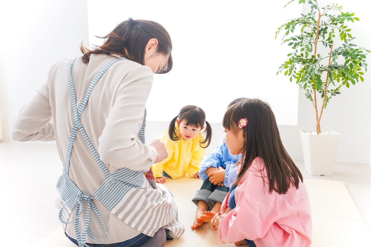 A stock photo of a woman playing with children (123rf)