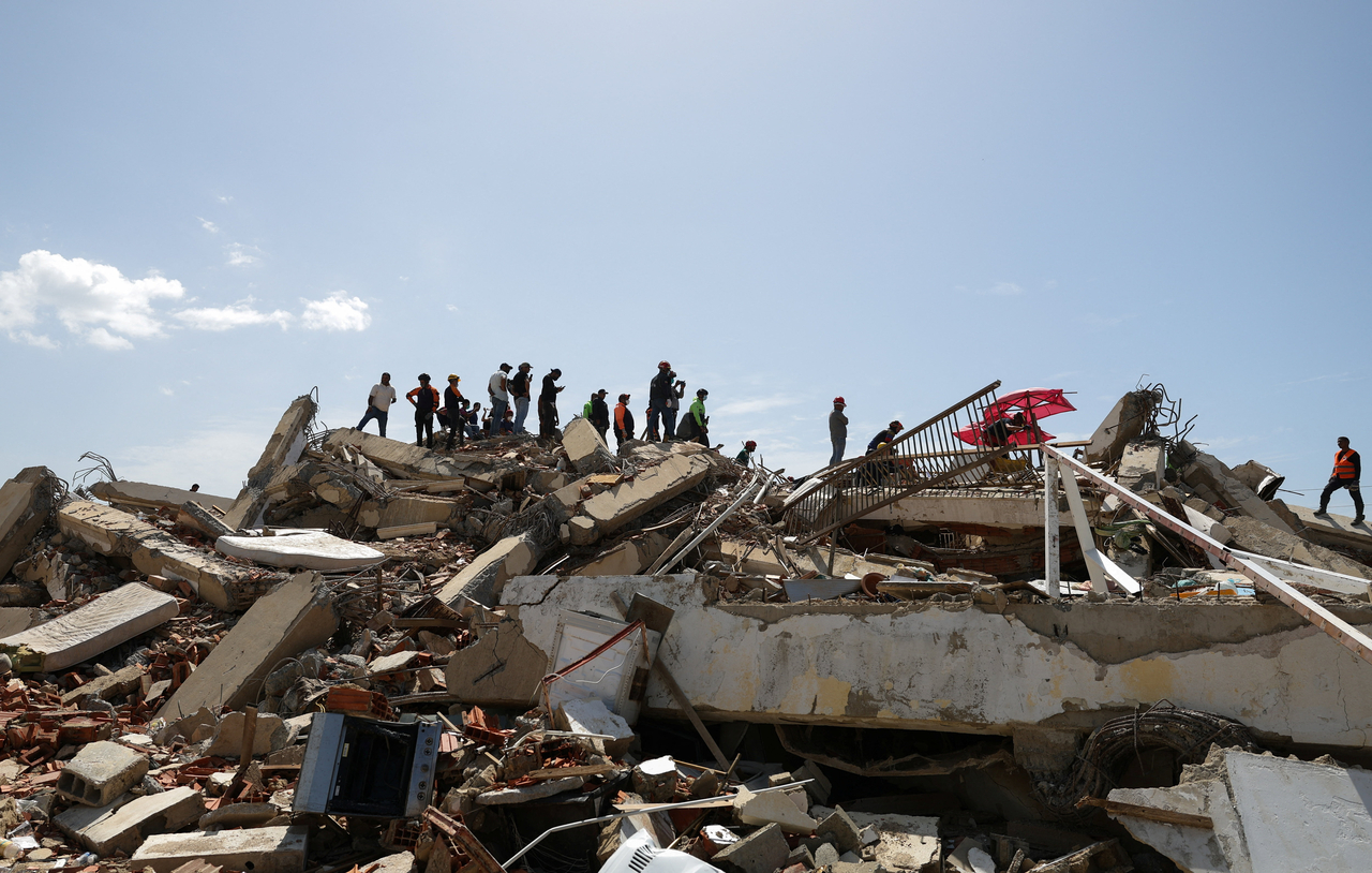 People stand on debris in the aftermath of earthquakes, in La Guaira, Venezuela, Wednesday. (Reuters-Yonhap)