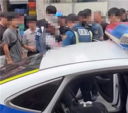 This photo provided to Yonhap News Agency by a subscriber shows police arresting a man who attacked two people with a knife at a beauty salon in Geoje, South Gyeongsang Province, on Thursday.