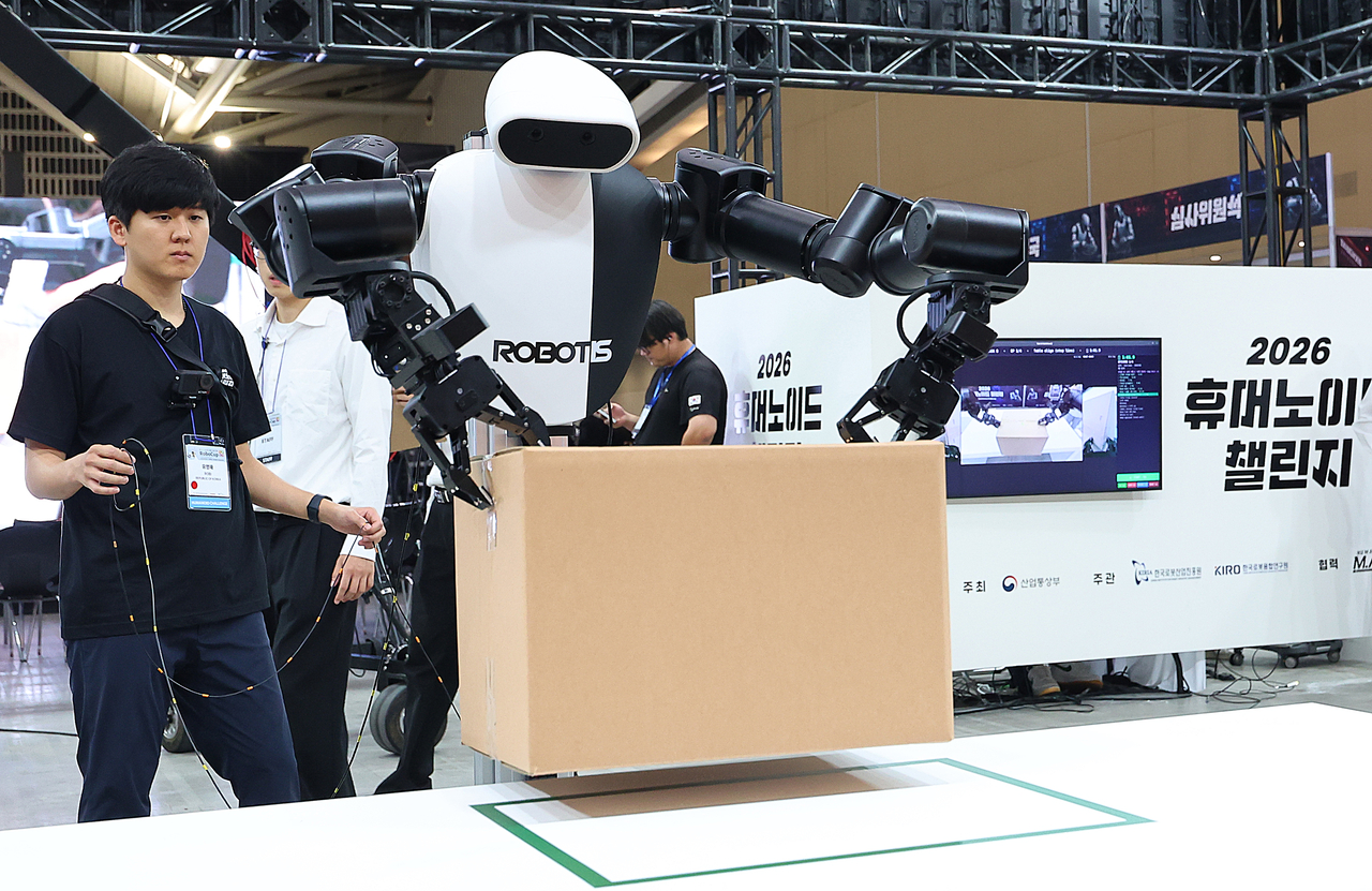 A robot attempts to place a box in a designated spot during the industrial automation league at the RoboCup 2026 Incheon on Thursday. (Yonhap)