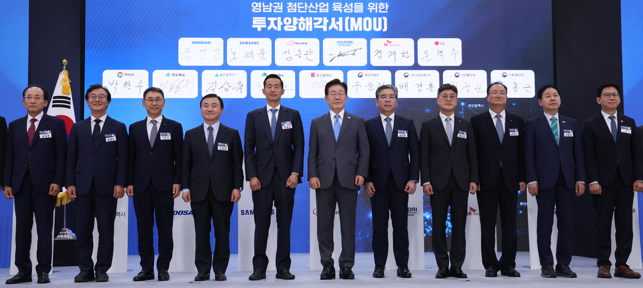 President Lee Jae Myung poses with government officials and business leaders after an investment agreement ceremony during a briefing on Yeongnam’s advanced industrial development vision in Jinju, South Gyeongsang Province, on Friday. From left: Daegu Mayor Choo Kyung-ho, Busan Mayor Jeon Jae-soo, Doosan Enerbility Vice Chairman Jung Yeon-in, Samsung Electronics President Roh Tae-moon, Hanwha Group Vice Chairman Kim Dong-kwan, President Lee Jae Myung, Hyundai Motor Group Vice Chairman Chang Jae-hoon, SK Telecom CEO Jung Jai-hun, LG Innotek CEO Moon Hyuk-soo, Deputy Prime Minister and Finance Minister Koo Yun-cheol, and Deputy Prime Minister and Science Minister Bae Kyung-hoon. (Yonhap)