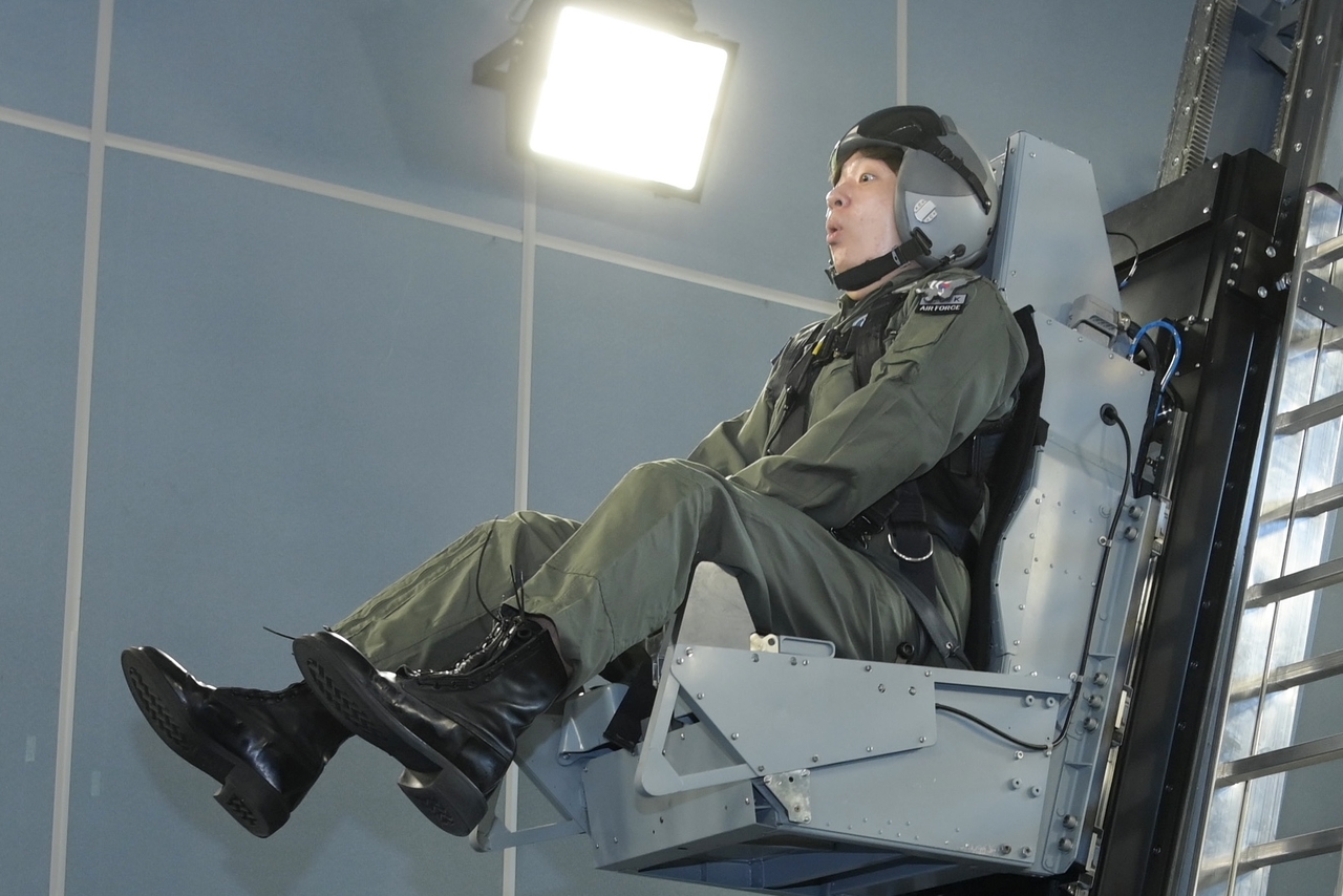 A trainee is lifted upward during emergency egress training. (Republic of Korea Air Force)