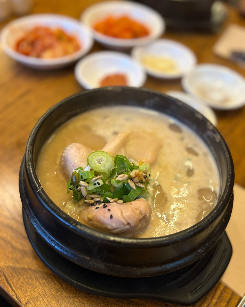 A bowl of samgyetang, Korean ginseng chicken soup with rice-stuffed young chicken, served in the traditional Tosokchon style with stone pot