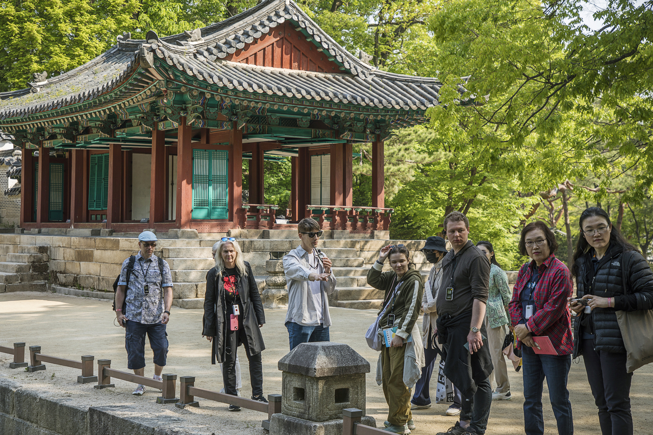 Visitors take part in the Awakening the Morning Palace program at Changdeokgung in April 2025. The early-morning tour offers participants to explore the palace before regular opening hours. (Korea Heritage Agency)