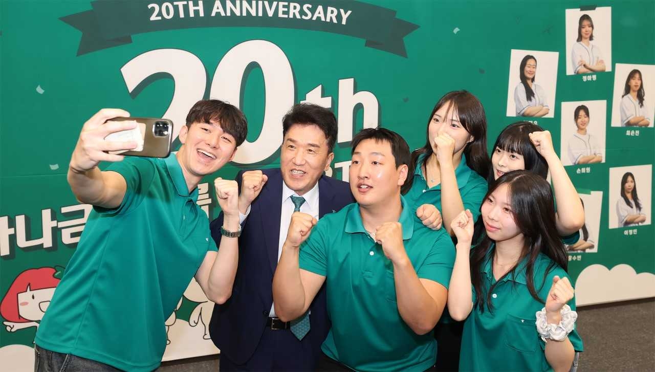 Hana Financial Group Chairman Ham Young-joo (second from left) poses for a photo with members of the group's 20th SMART student ambassador program at an inauguration ceremony held at its headquarters in Myeong-dong, Seoul, Thursday. (Hana Financial Group)
