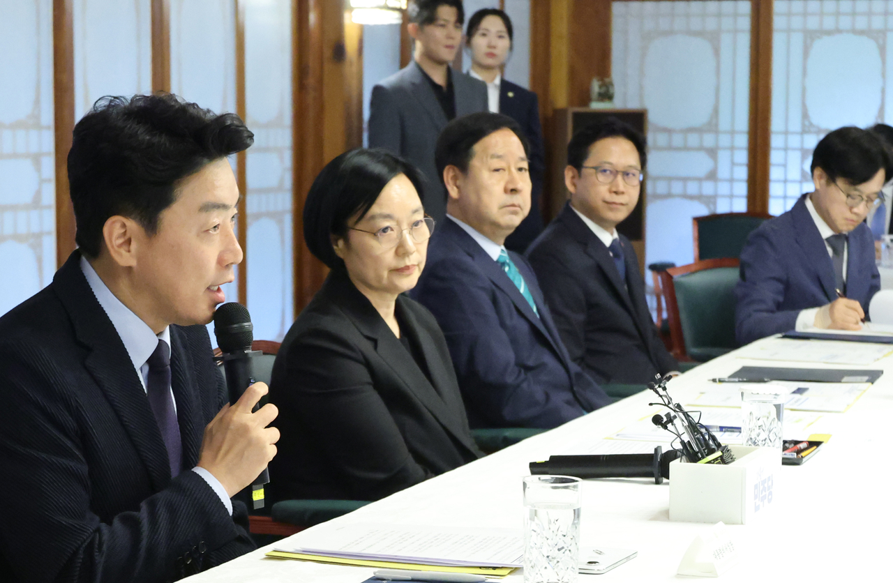 Presidential chief of staff Kang Hoon-sik (first from left) speaks during a meeting with the government and the ruling Democratic Party of Korea presided by Prime Minister Han Seong-sook (second from left) held in Seoul on Sunday. (Yonhap)