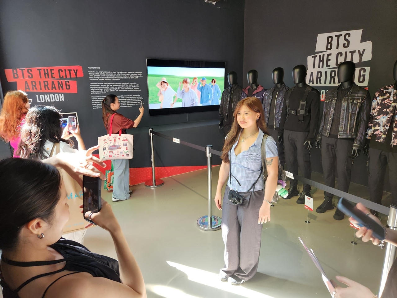 A fan takes a photo in front of BTS' outfits from the 2019 BTS 'Love Yourself: Speak Yourself' Wembley concert in the Korean Cultural Centre UK during BTS The City Arirang London on July 4 (Yonhap)