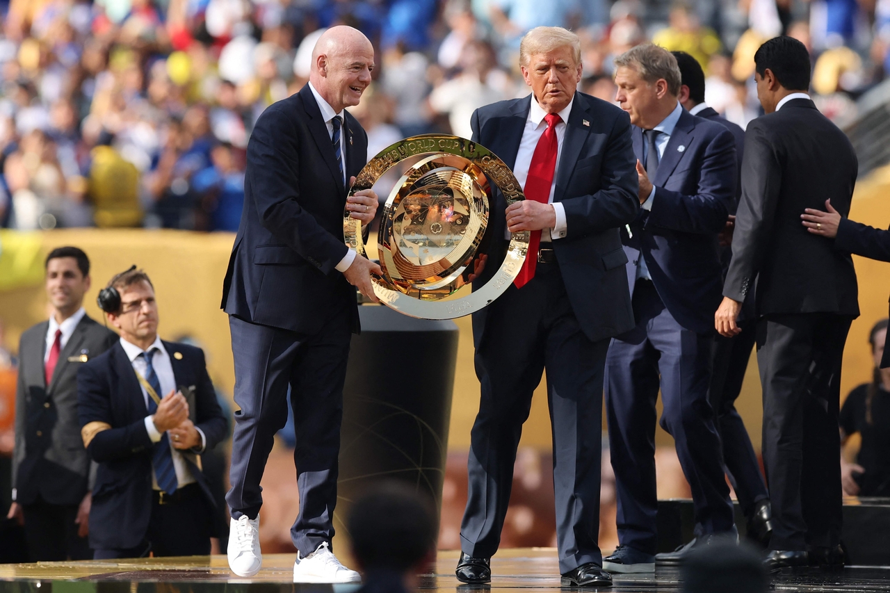 President Donald Trump and FIFA President Gianni Infantino hold up the championship trophy. [AFP]