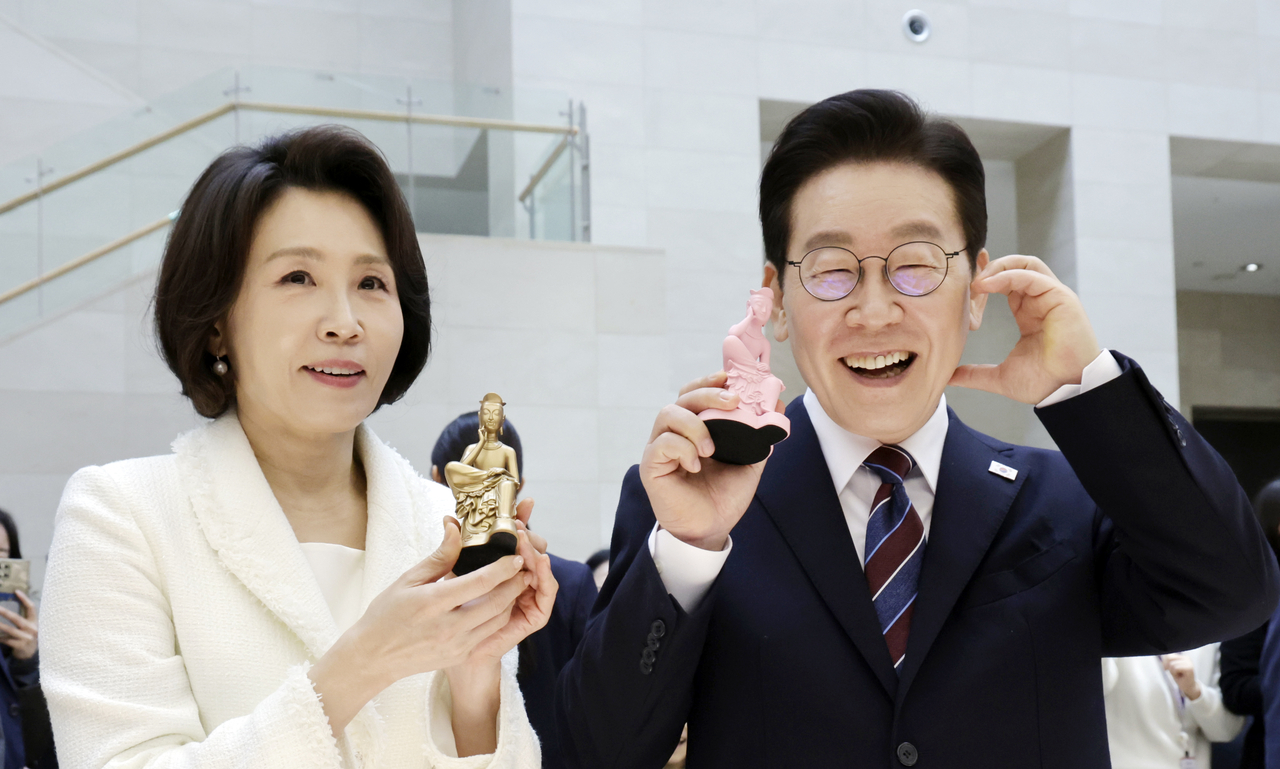 President Lee Jae Myung and first lady Kim Hea Kyung pose for photos, holding a miniature replica of the gilt-bronze Pensive Bodhisattva, after visiting the National Museum of Korea in Seoul on Feb. 26. (Yonhap)