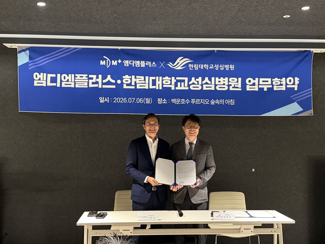 Kim Hyeong-su (right), president of Hallym University Sacred Heart Hospital, and Gu Myeong-wan (left), CEO of MDM Plus, pose for a photo after signing the MOU. [MDM Plus]