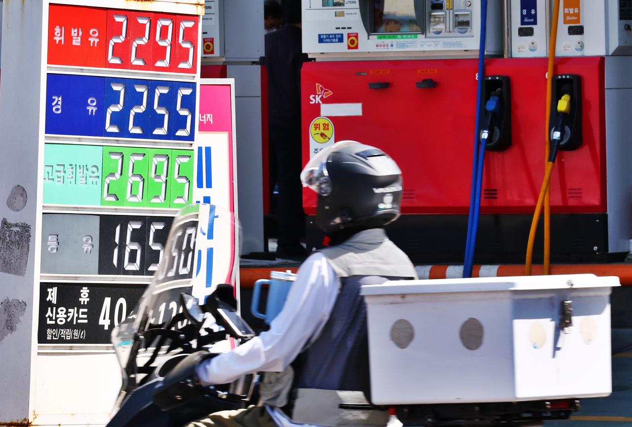 This file photo, taken April 24, shows a motorcycle rider driving past a gas station in Seoul. (Yonhap)