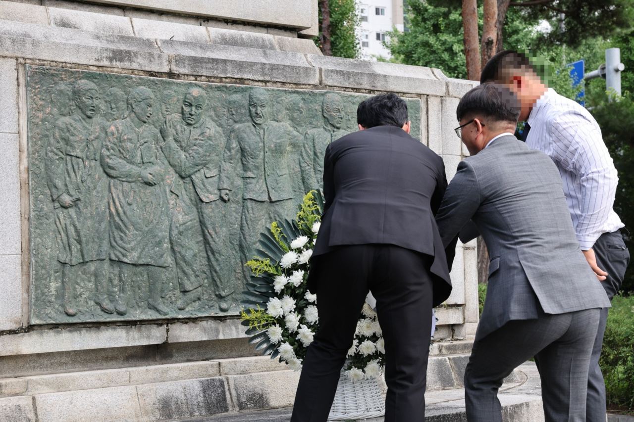 A student representative from Paichai High School (right) pays respects at a memorial to the Gwangju Student Independence Movement alongside officials from Paichai High School and Gwangju Jeil High School on Monday in Gwangju. (Seoul Metropolitan Office of Education)