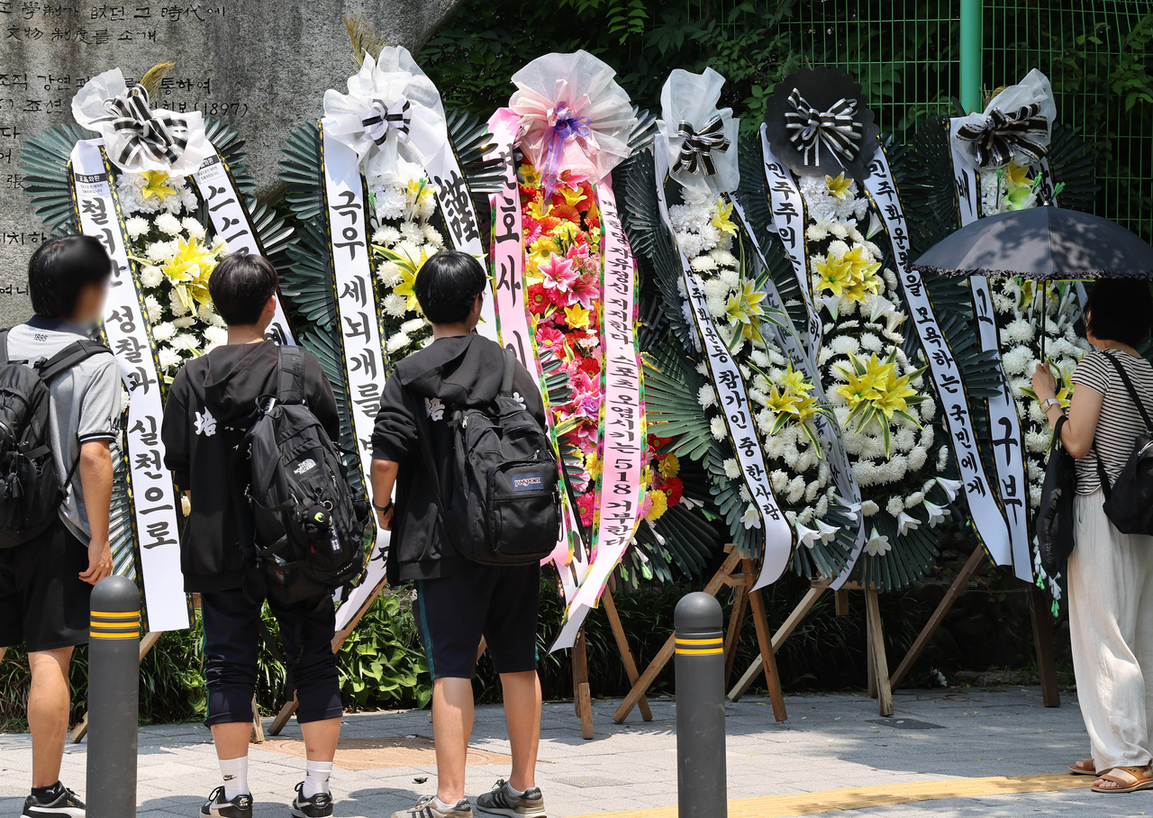 Wreaths criticizing and supporting Paichai High School following the cheering controversy are seen in front of the school in eastern Seoul on Wednesday. (Yonhap)