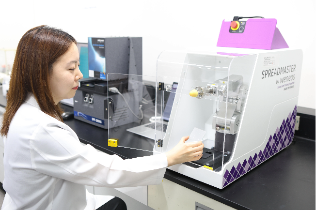 A Cosmax researcher measures the sun protection factor of a sun care product using a robotic arm system. (Cosmax)