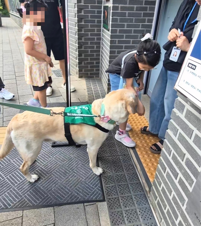 A young girl pets ChamE after a reading session. (Choi Jae-hee/The Korea Herald)
