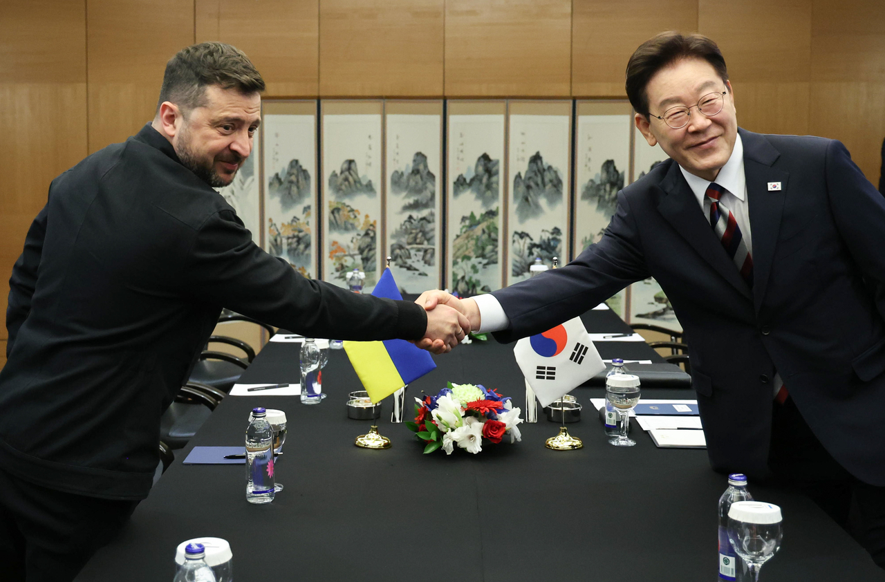 President Lee Jae Myung (right) and Ukrainian President Volodymyr Zelenskyy shake hands ahead of their summit meeting at a hotel in Ankara, Turkey, on Wednesday. (Yonhap)