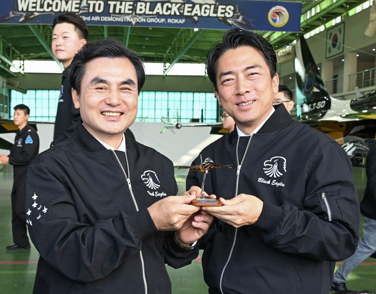 Defense Minister Ahn Gyu-back (left) presents a Black Eagles model aircraft souvenir to Japanese Defense Minister Shinjiro Koizumi during their visit to a South Korean Air Force unit home to the Black Eagles aerobatic team in Wonju, Gangwon Province, about 90 kilometers southeast of Seoul, on June 27, the first day of Koizumi's two-day visit to South Korea. (Ministry of National Defense)