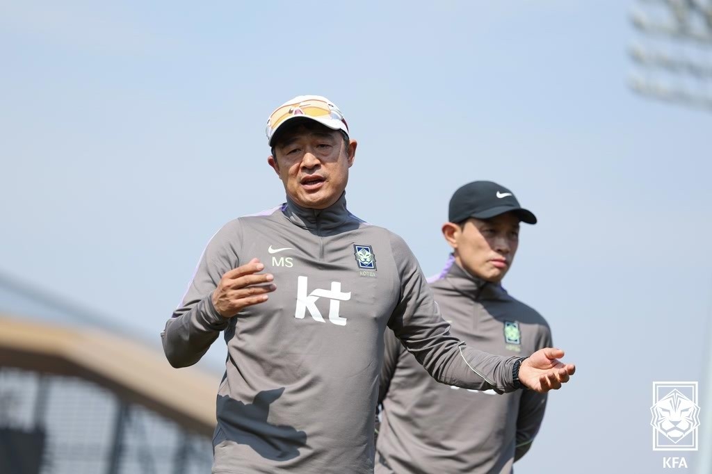 Lee Min-sung (L), head coach of the South Korean men's under-23 national football team, speaks to his players during a training session at Korea Football Park in Cheonan, South Chungcheong Province, on March 24. (Korea Football Association)