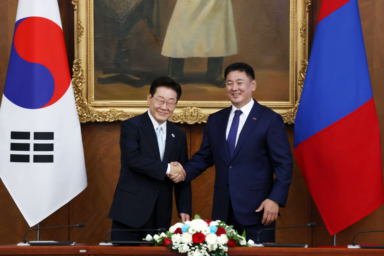 President Lee Jae Myung (left) shakes hands with Mongolian President Ukhnaagiin Khurelsukh ahead of their summit at the Government Palace in Ulaanbaatar on Thursday. (Yonhap)