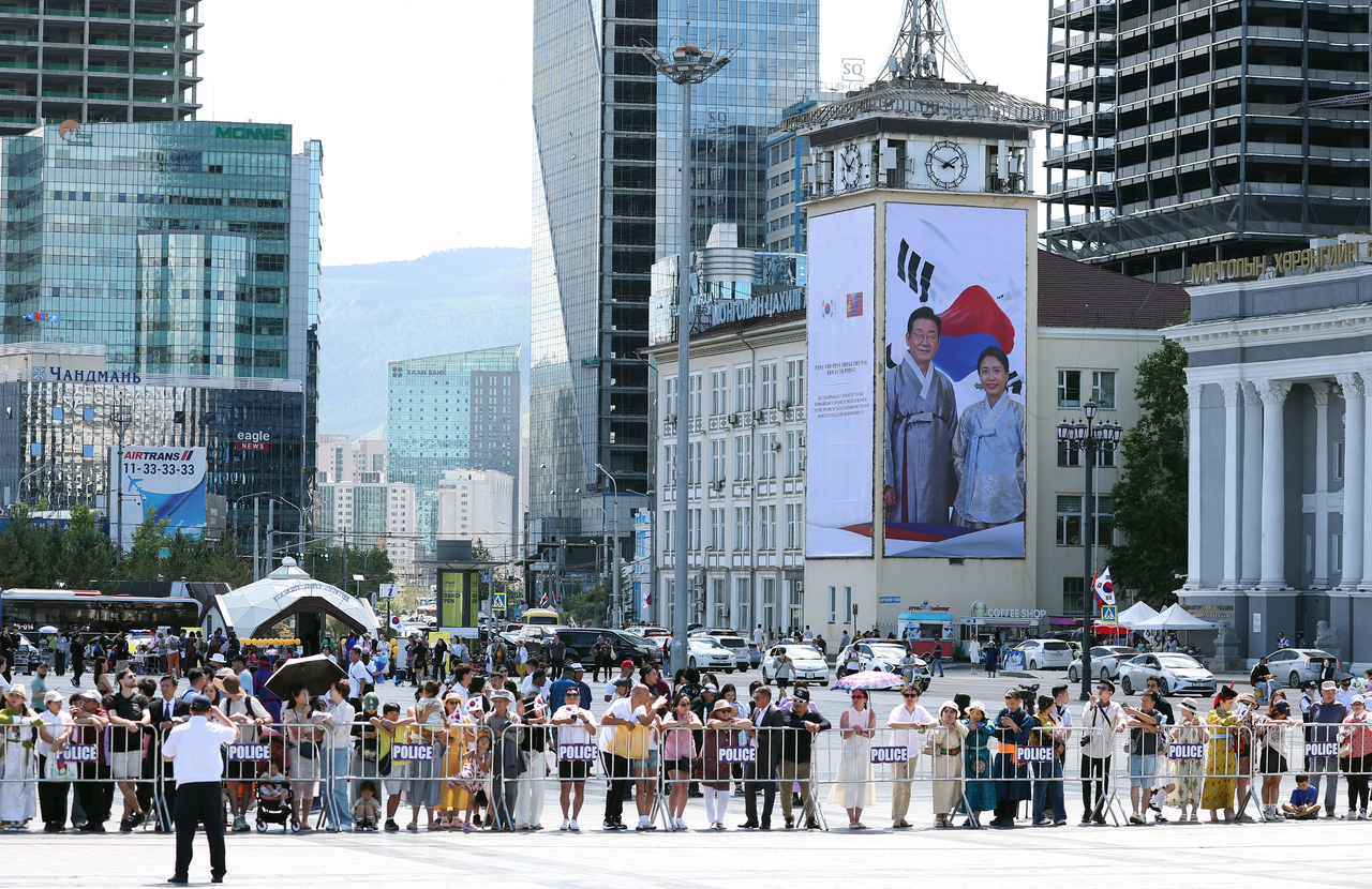 A large banner featuring President Lee Jae Myung and first lady Kim Hea Kyung dressed in traditional Korean hanbok hangs on a building overlooking Sukhbaatar Square in Ulaanbaatar on Thursday, ahead of the official welcoming ceremony for Lee’s state visit to Mongolia. (Yonhap)
