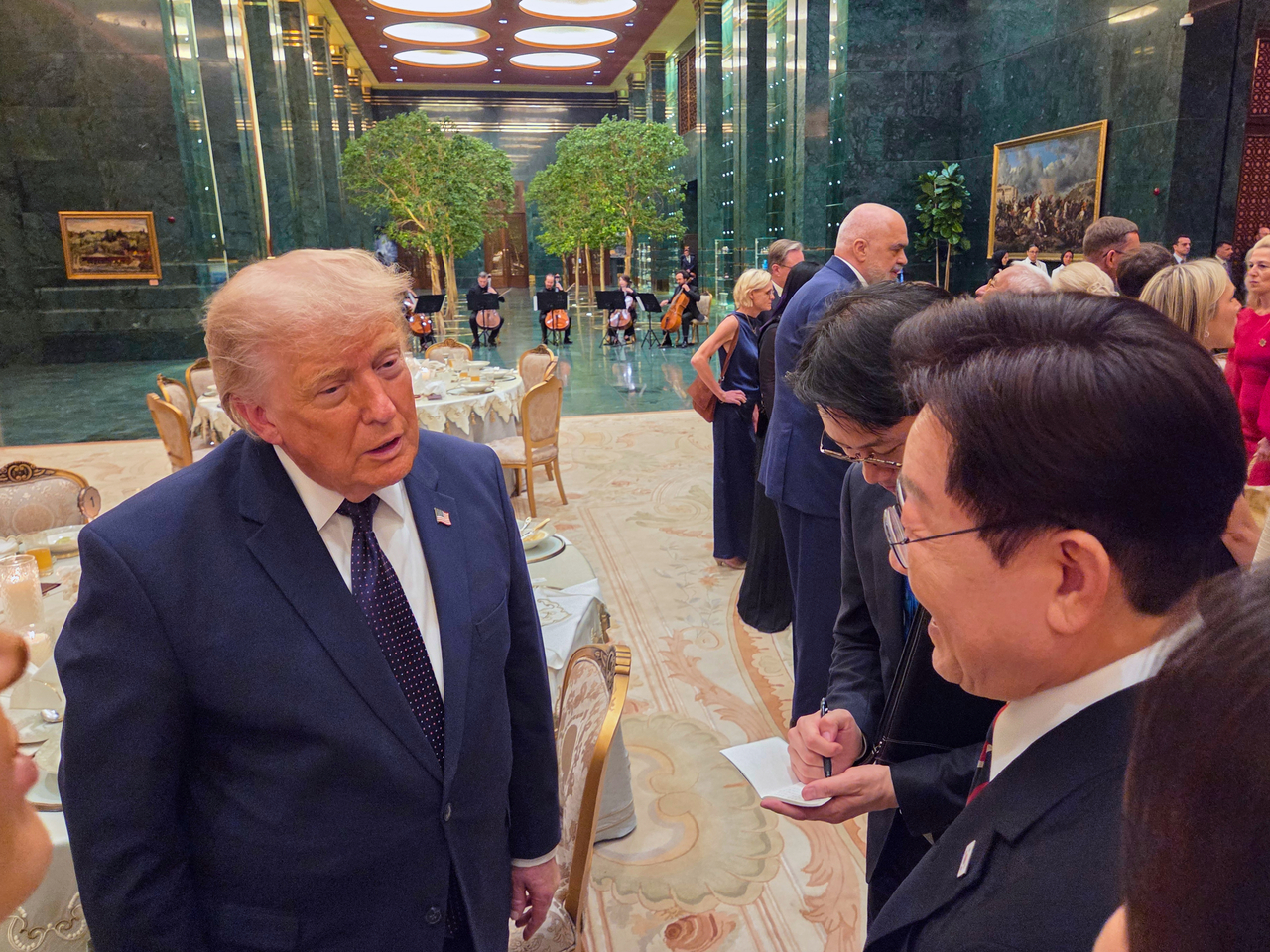 President Lee Jae Myung speaks with US President Donald Trump during an official welcome dinner for leaders attending the NATO summit, hosted by Turkish President Recep Tayyip Erdogan and first lady Emine Erdogan at the Presidential Complex in Ankara, Turkey, on Tuesday. (Pool Photo via Yonhap)