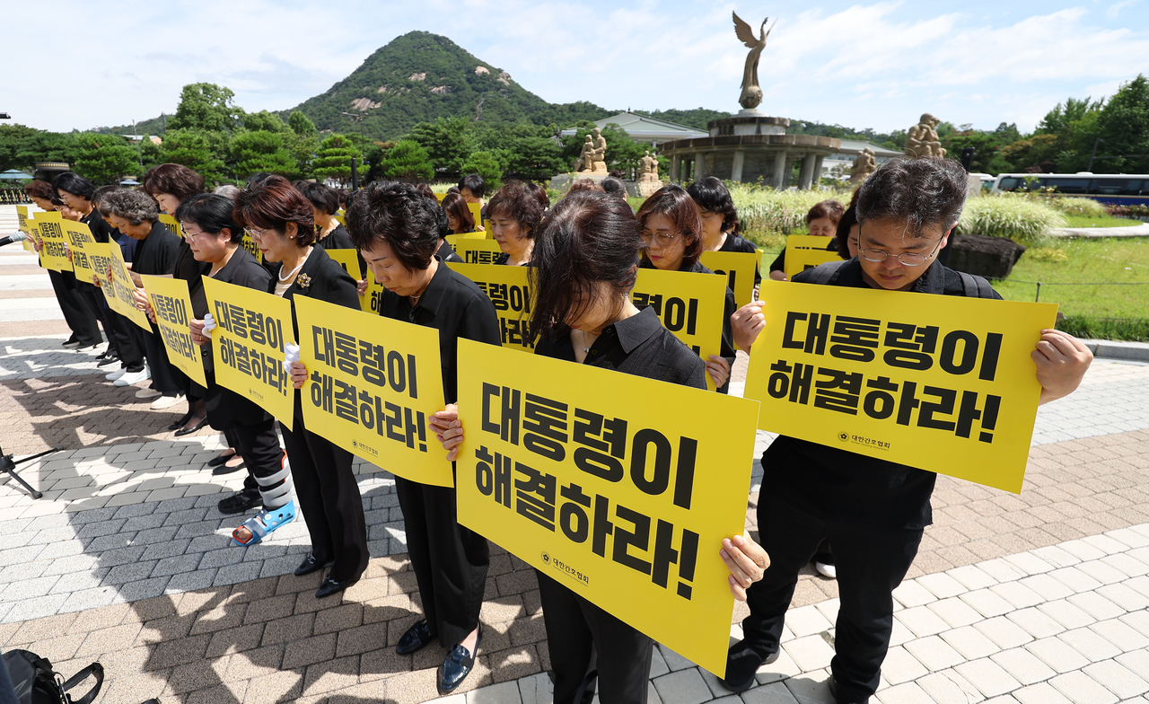 Members of the Korean Nurses Association hold a moment of silence for Kang Soo-bin, a nurse who was found dead in Gwangju, Gyeonggi Province, amid allegations of workplace bullying, during a press conference in front of Cheong Wa Dae in central Seoul on Monday. (Newsis)
