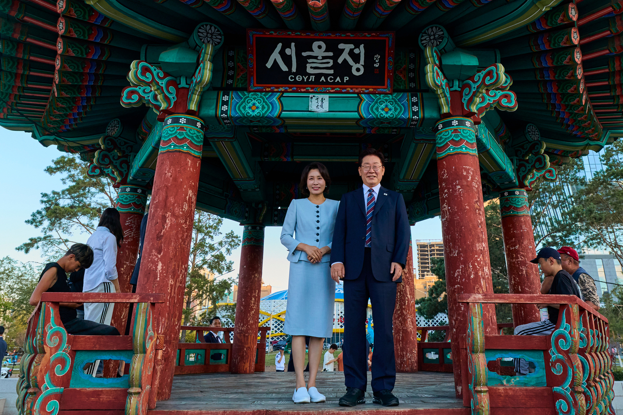 President Lee Jae Myung and first lady Kim Hea Kyung pose for a photo in front of Seoul Jung, a traditional Korean pavilion, on Seoul Street in Ulaanbaatar on Thursday. (Yonhap)