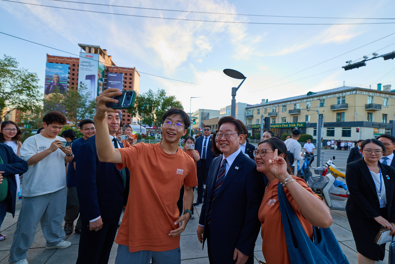 People take photos with President Lee Jae Myung on Seoul Street in Ulaanbaatar on Thursday. (Yonhap)