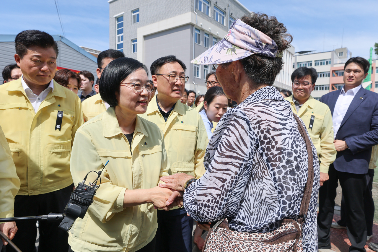 Prime Minister Han Seong-suk listens to residents during a visit to the flood-damaged Mochung-dong neighborhood in Cheongju, North Chungcheong Province, on Saturday. [Yonhap]